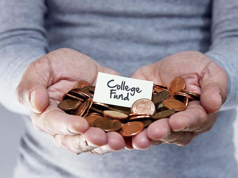 hands holding pennies and sign reading college fund